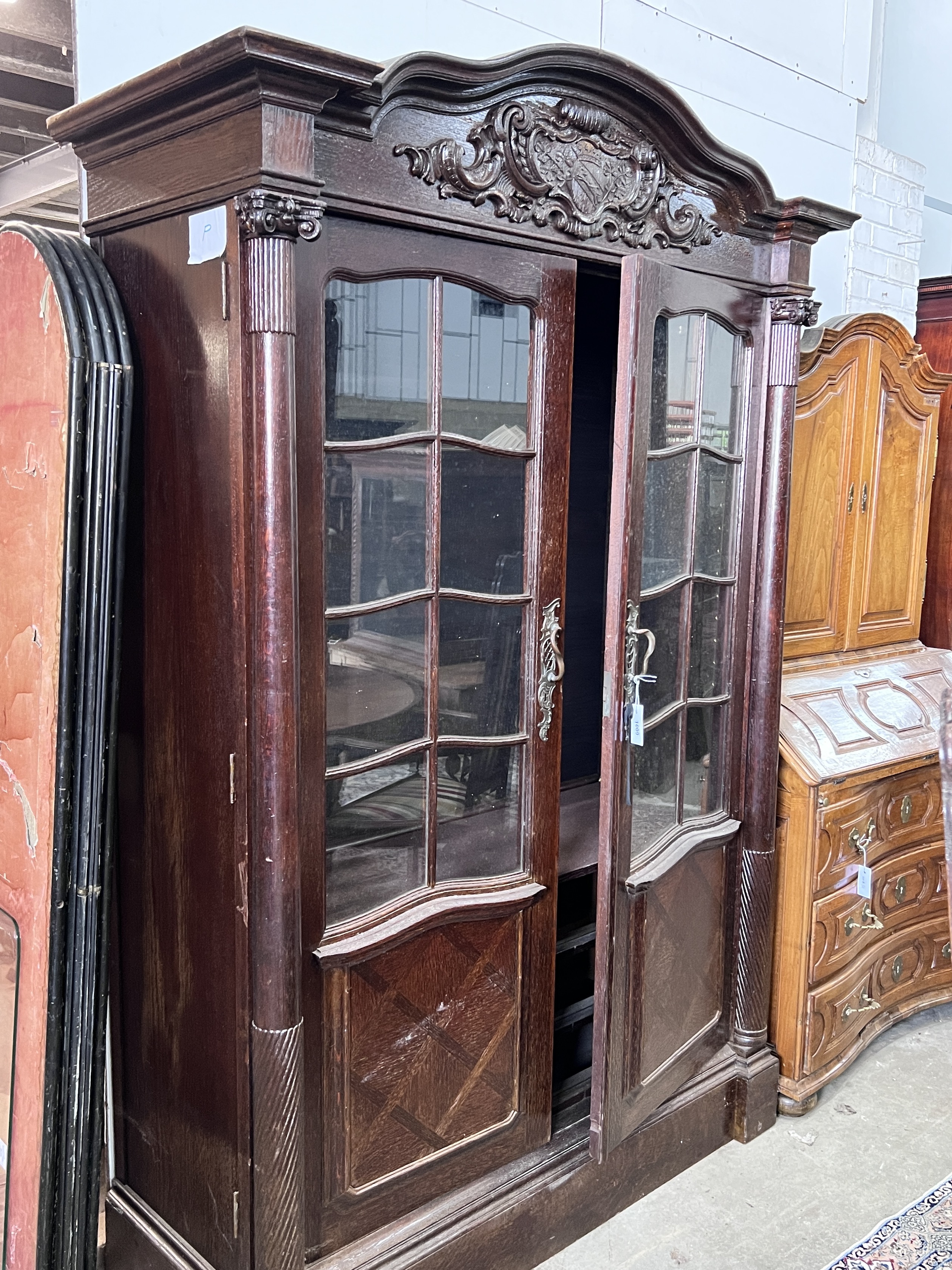 An early 20th century continental oak bookcase, lacking shelves and interior drawers, width 143cm, depth 58cm, height 198cm